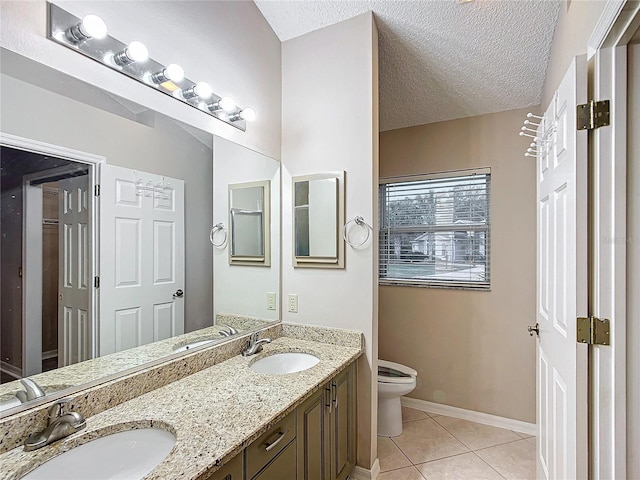 bathroom featuring tile patterned floors, vanity, toilet, and a textured ceiling