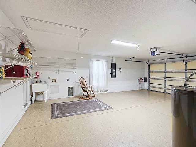 garage featuring electric panel, sink, a garage door opener, and water heater