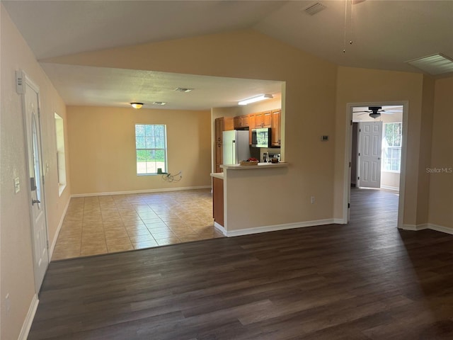 unfurnished living room featuring ceiling fan, dark wood-type flooring, and vaulted ceiling