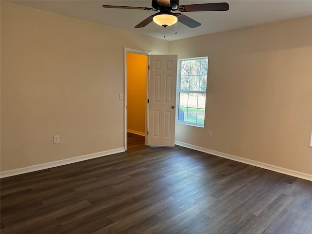 empty room with ceiling fan and dark hardwood / wood-style flooring