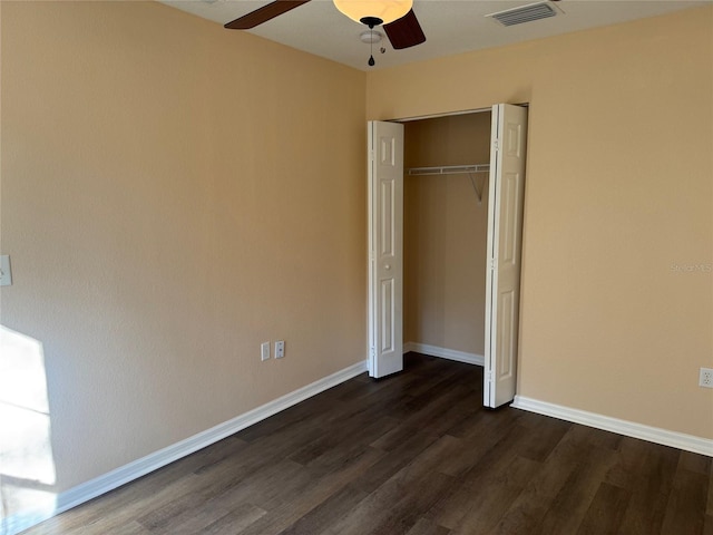 unfurnished bedroom featuring ceiling fan, dark hardwood / wood-style flooring, and a closet