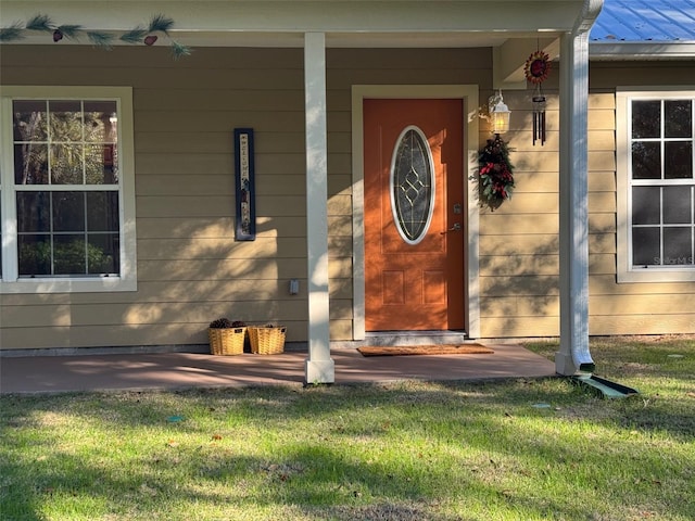 property entrance featuring a porch and a yard