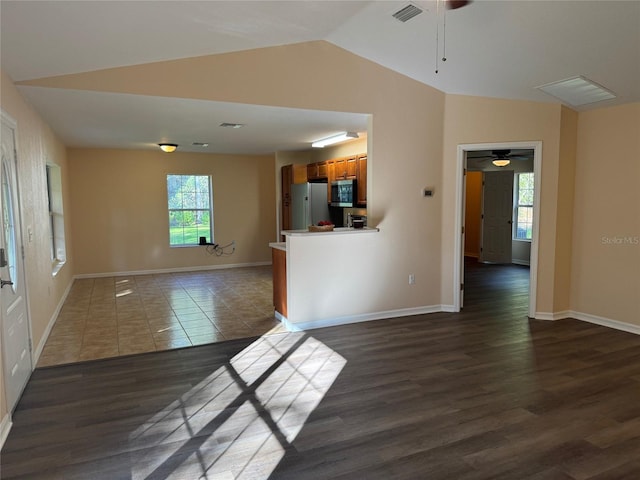 unfurnished living room featuring plenty of natural light, dark hardwood / wood-style floors, and ceiling fan