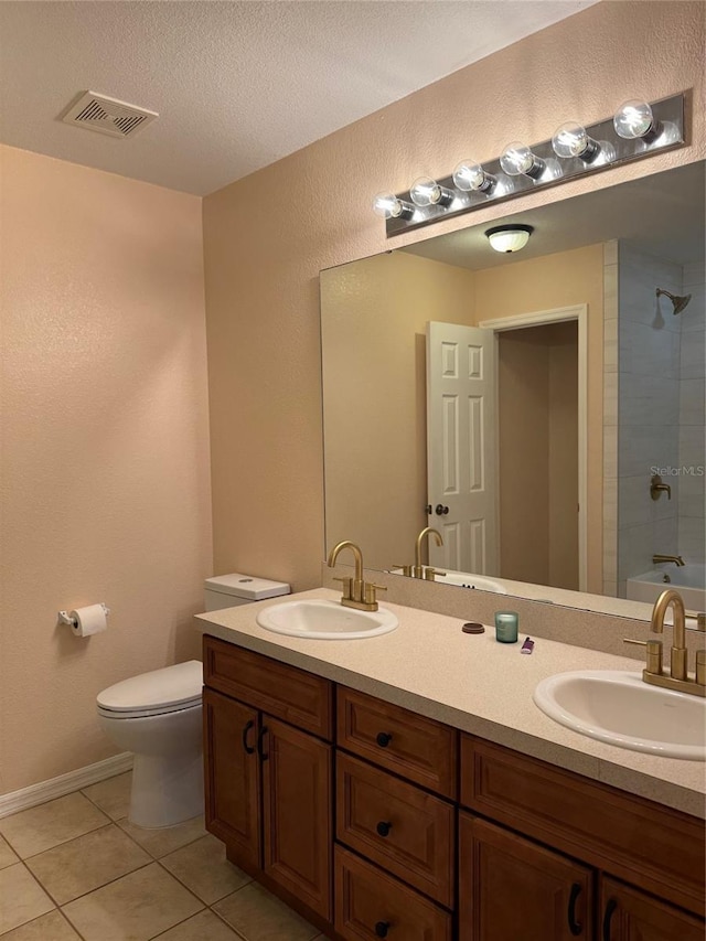 full bathroom featuring tile patterned floors, vanity, toilet, and tiled shower / bath