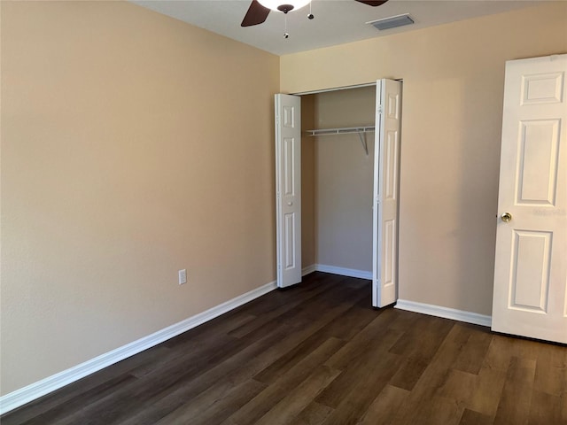 unfurnished bedroom with dark hardwood / wood-style flooring, a closet, and ceiling fan