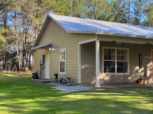 rear view of property with a lawn and ceiling fan