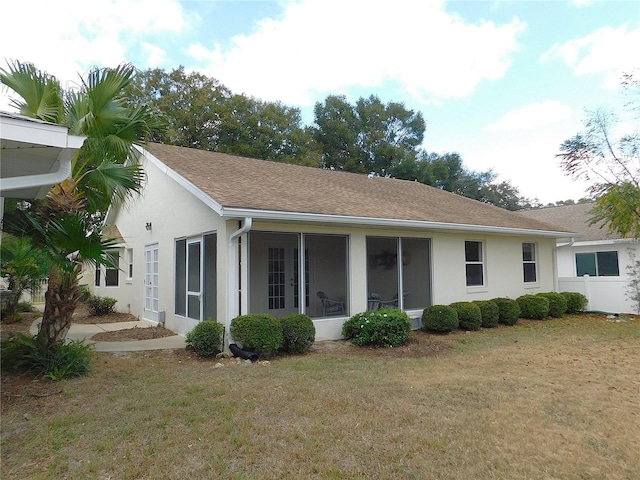 back of house with a sunroom and a yard