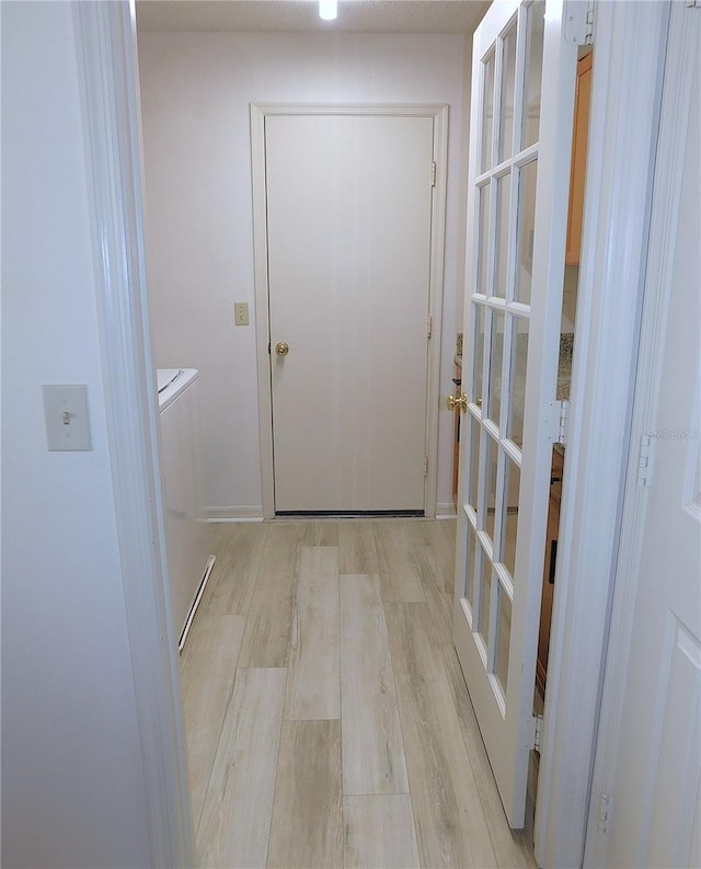 hallway featuring washer / dryer and light wood-type flooring