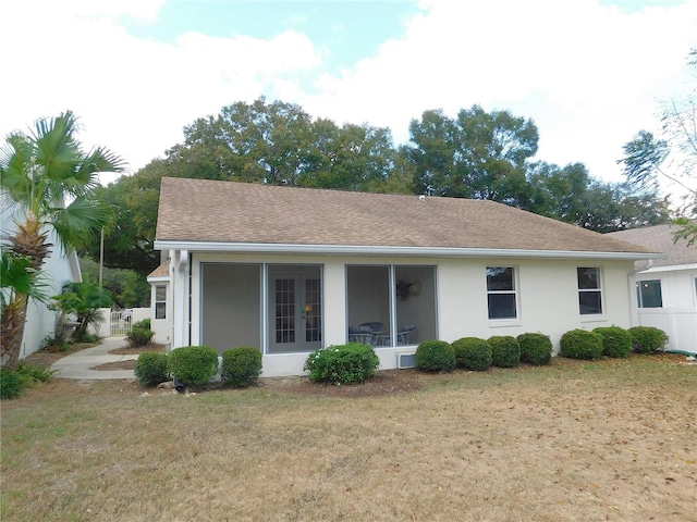 back of property featuring a yard and a sunroom