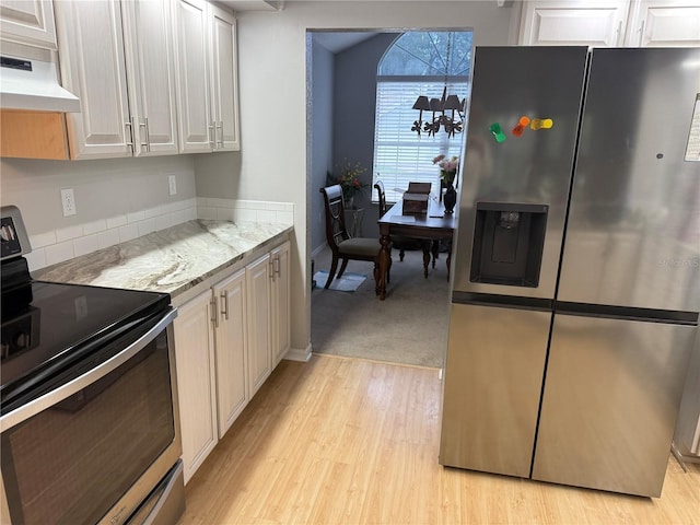 kitchen featuring light stone countertops, white cabinetry, stainless steel appliances, and exhaust hood