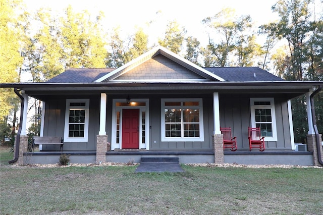 view of front of home with a porch and a front yard