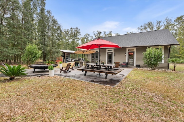 back of property with a patio area and a lawn