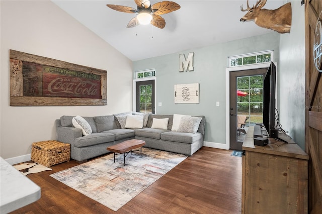 living room with dark hardwood / wood-style flooring, ceiling fan, and a healthy amount of sunlight