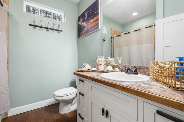 bathroom featuring vanity, hardwood / wood-style flooring, curtained shower, and toilet