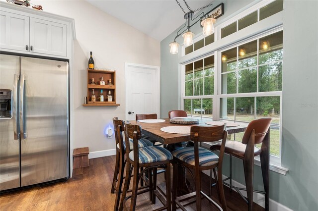 dining space featuring dark wood-type flooring and lofted ceiling