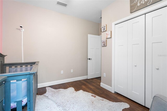 bedroom featuring dark hardwood / wood-style floors and a closet