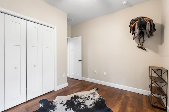 bedroom featuring dark hardwood / wood-style floors and a closet