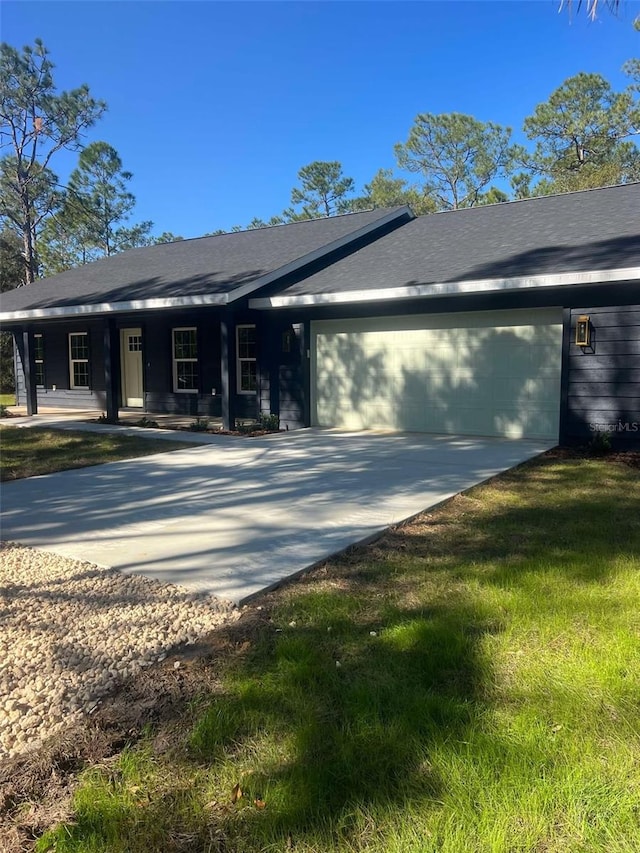 view of side of property featuring concrete driveway, a garage, and a shingled roof