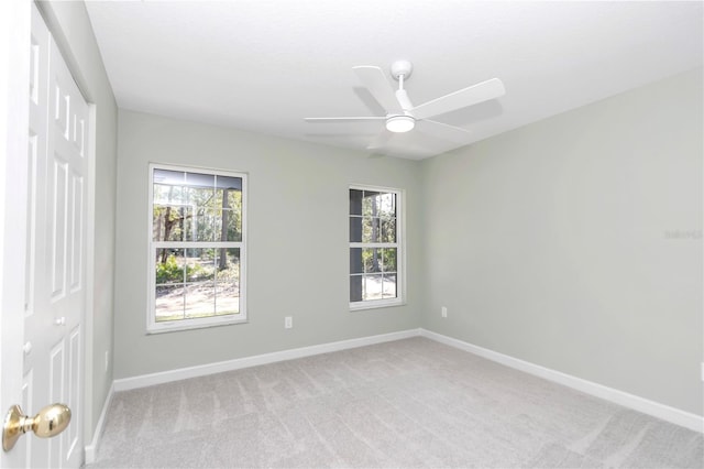 spare room featuring ceiling fan and light colored carpet