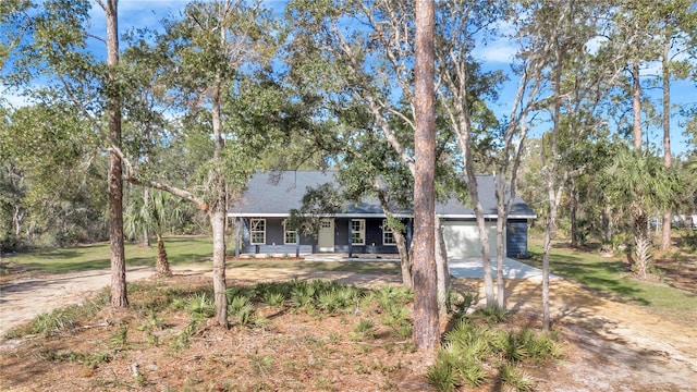 ranch-style home featuring a front yard, covered porch, and a garage