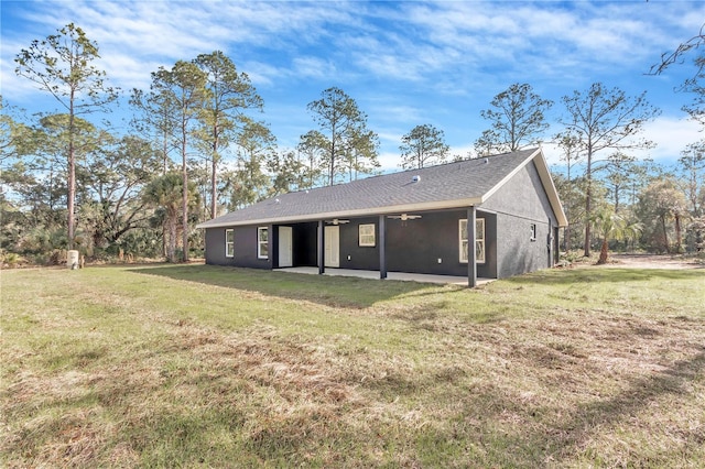 rear view of property with ceiling fan, a patio area, and a yard