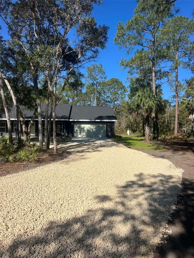 exterior space featuring a garage and gravel driveway