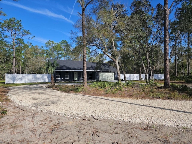 ranch-style house featuring fence and driveway