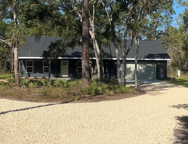 view of front of home with a porch, driveway, and a garage