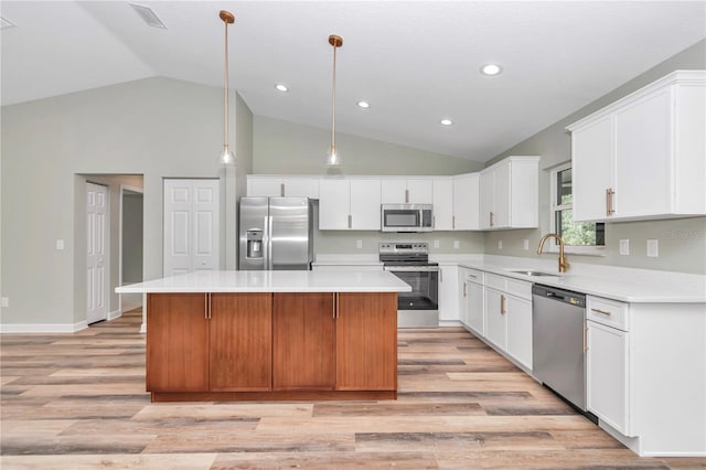 kitchen featuring a sink, appliances with stainless steel finishes, a center island, and light wood finished floors