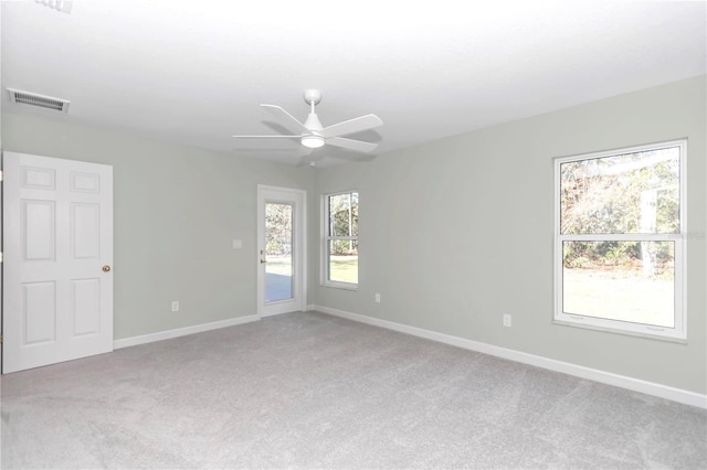 carpeted empty room featuring visible vents, baseboards, and ceiling fan