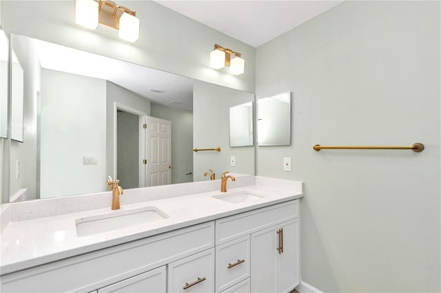 bathroom featuring double vanity, baseboards, and a sink