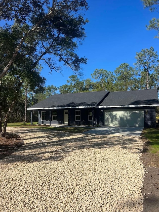 view of front of property featuring driveway, covered porch, and an attached garage