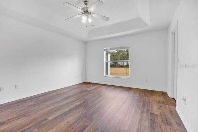 spare room with hardwood / wood-style flooring, ceiling fan, and a tray ceiling