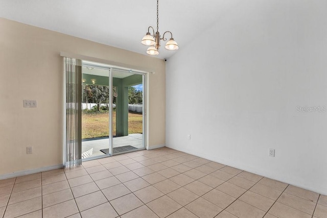 tiled spare room featuring a notable chandelier