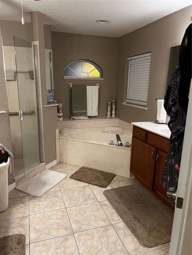 bathroom featuring tile patterned floors, vanity, a textured ceiling, and shower with separate bathtub