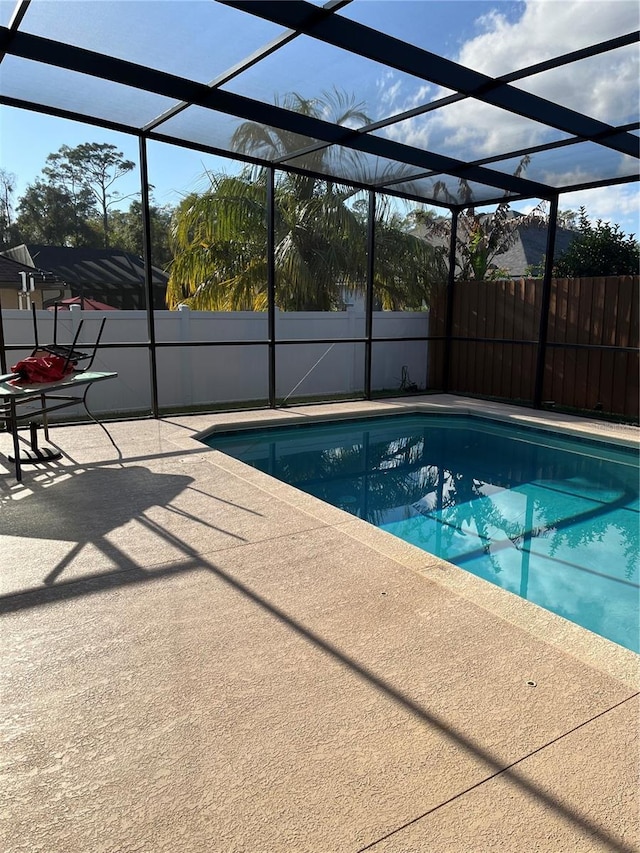 view of pool featuring glass enclosure and a patio