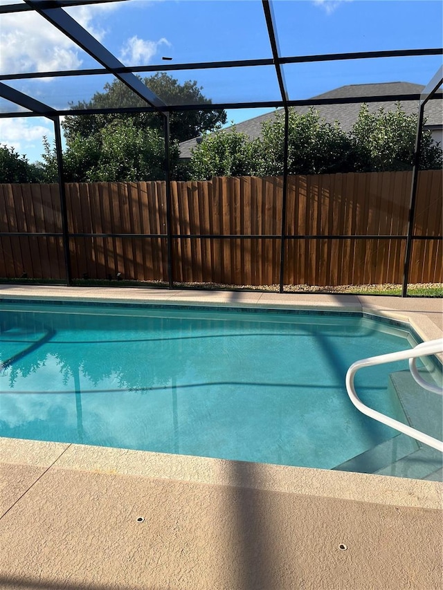 view of swimming pool featuring a lanai