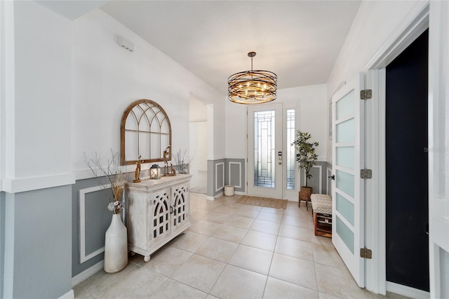 foyer featuring light tile patterned floors and an inviting chandelier