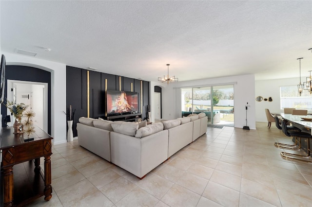 tiled living room with a chandelier and a textured ceiling