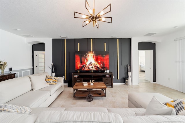 living room with light tile patterned flooring, a textured ceiling, and a chandelier