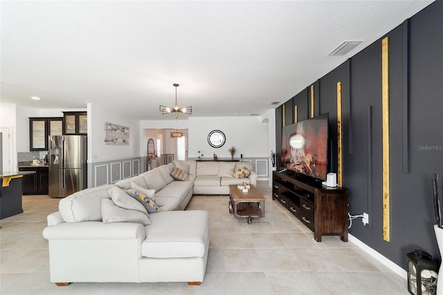 living room featuring light tile patterned floors and a notable chandelier