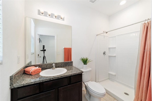 bathroom with tile patterned floors, a shower with curtain, toilet, and vanity