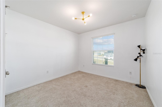 spare room with light colored carpet and a notable chandelier