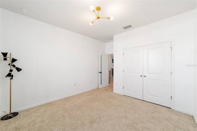 unfurnished bedroom with a closet and light colored carpet