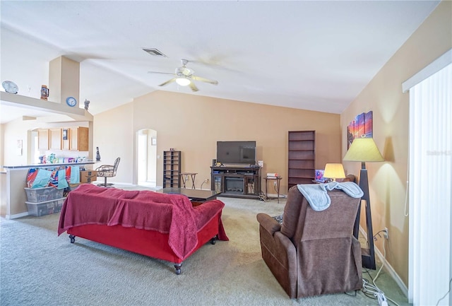 living room with light carpet, a fireplace, ceiling fan, and lofted ceiling