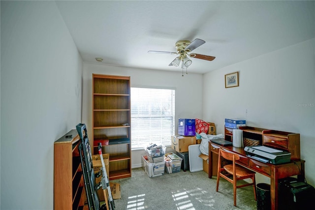 carpeted office space featuring ceiling fan