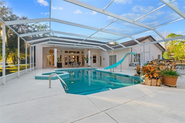 view of swimming pool featuring glass enclosure, ceiling fan, a patio, and a water slide