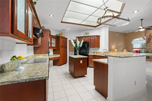 kitchen featuring kitchen peninsula, decorative backsplash, a kitchen island, and ceiling fan