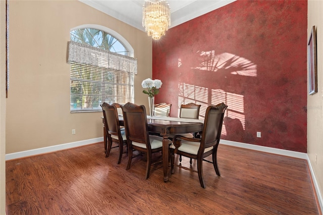 dining space with a chandelier, dark wood-type flooring, and ornamental molding