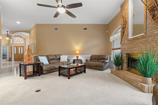 living room with ceiling fan, ornamental molding, a fireplace, and carpet floors